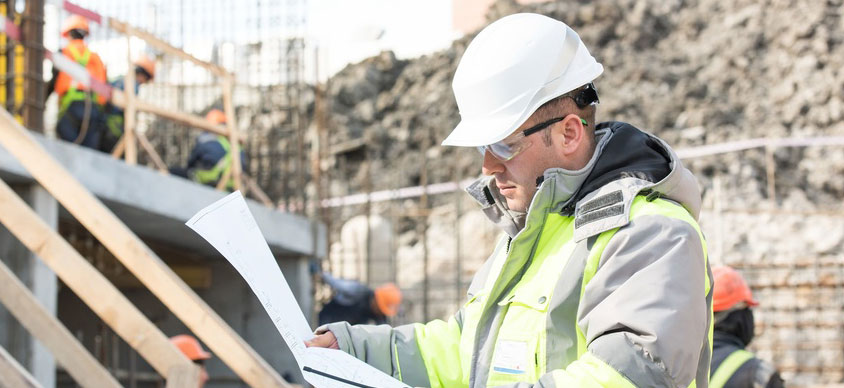 asbestos surveyor looking at plans of a property